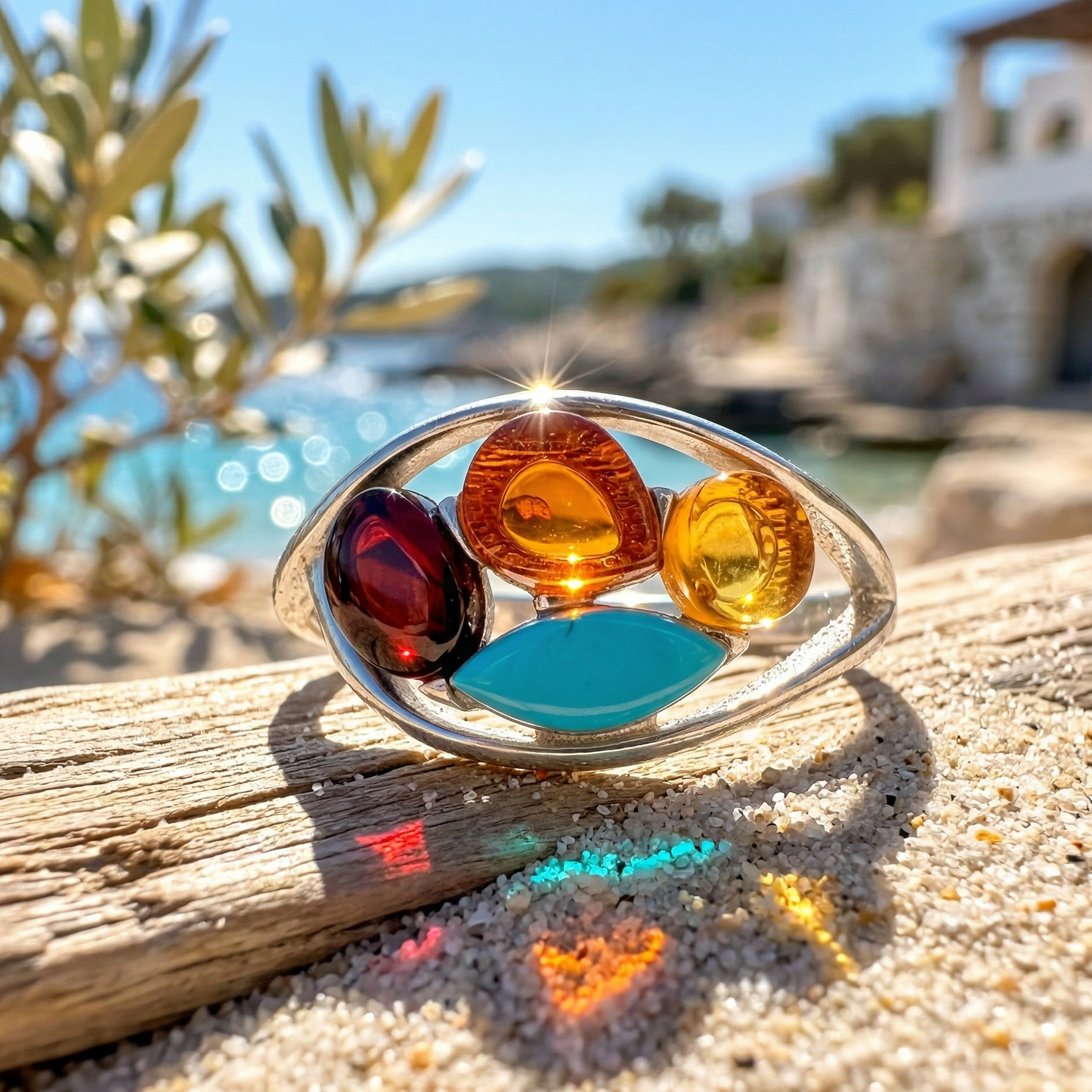 Colorful gemstone ring on a sandy surface with a scenic background