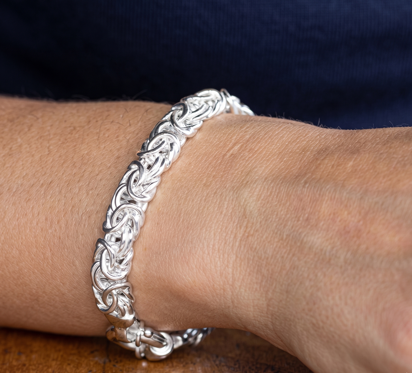 Silver bracelet on a wrist with a blurred background