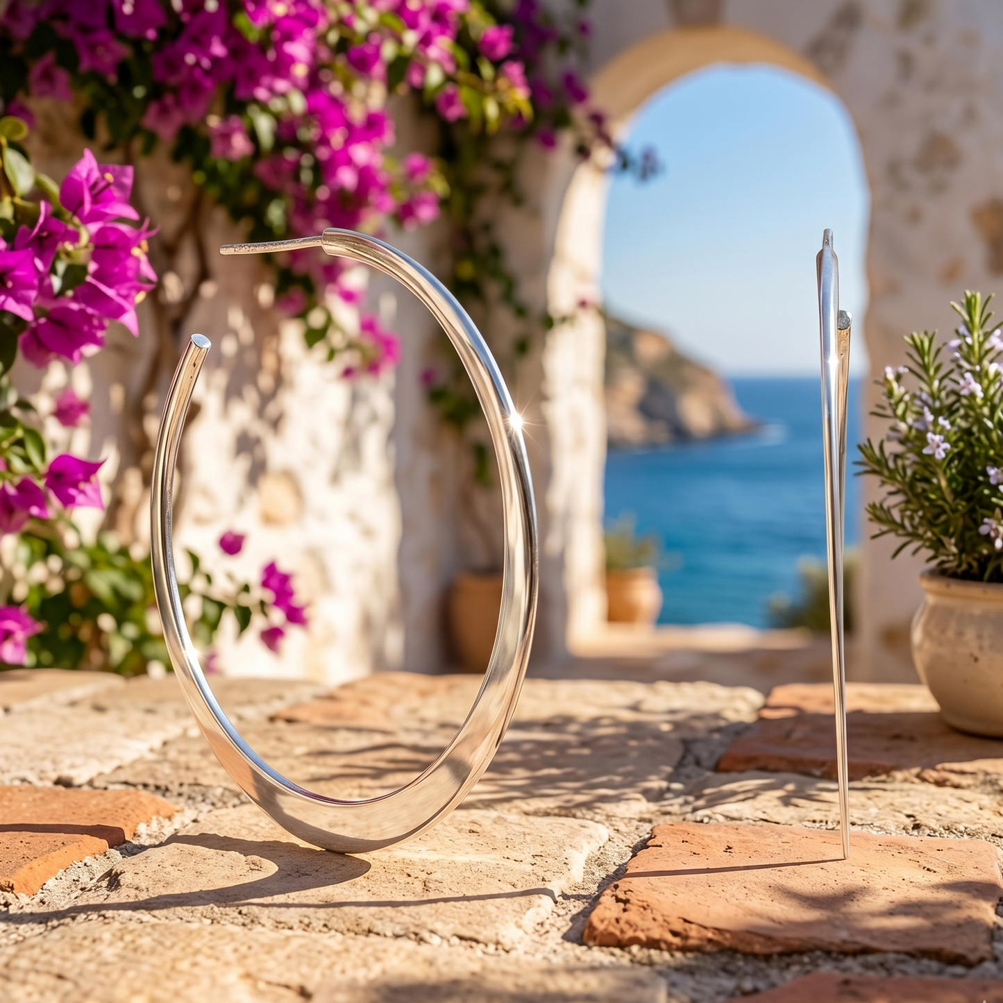 Silver circular object on a stone surface with flowers and a scenic background
