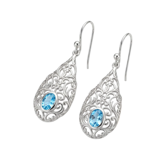 Silver earrings with blue gemstones on a wooden surface
