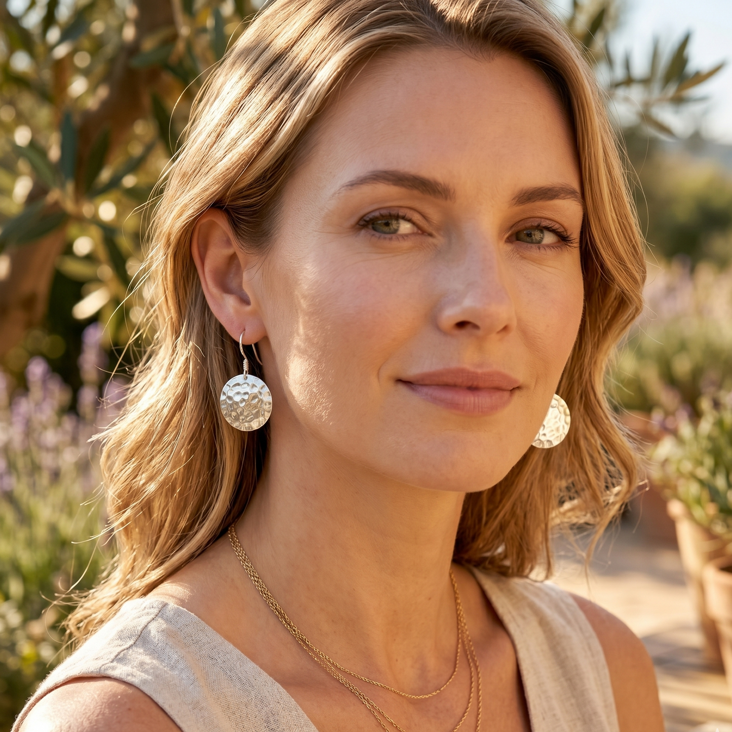 Woman wearing silver earrings in a garden setting
