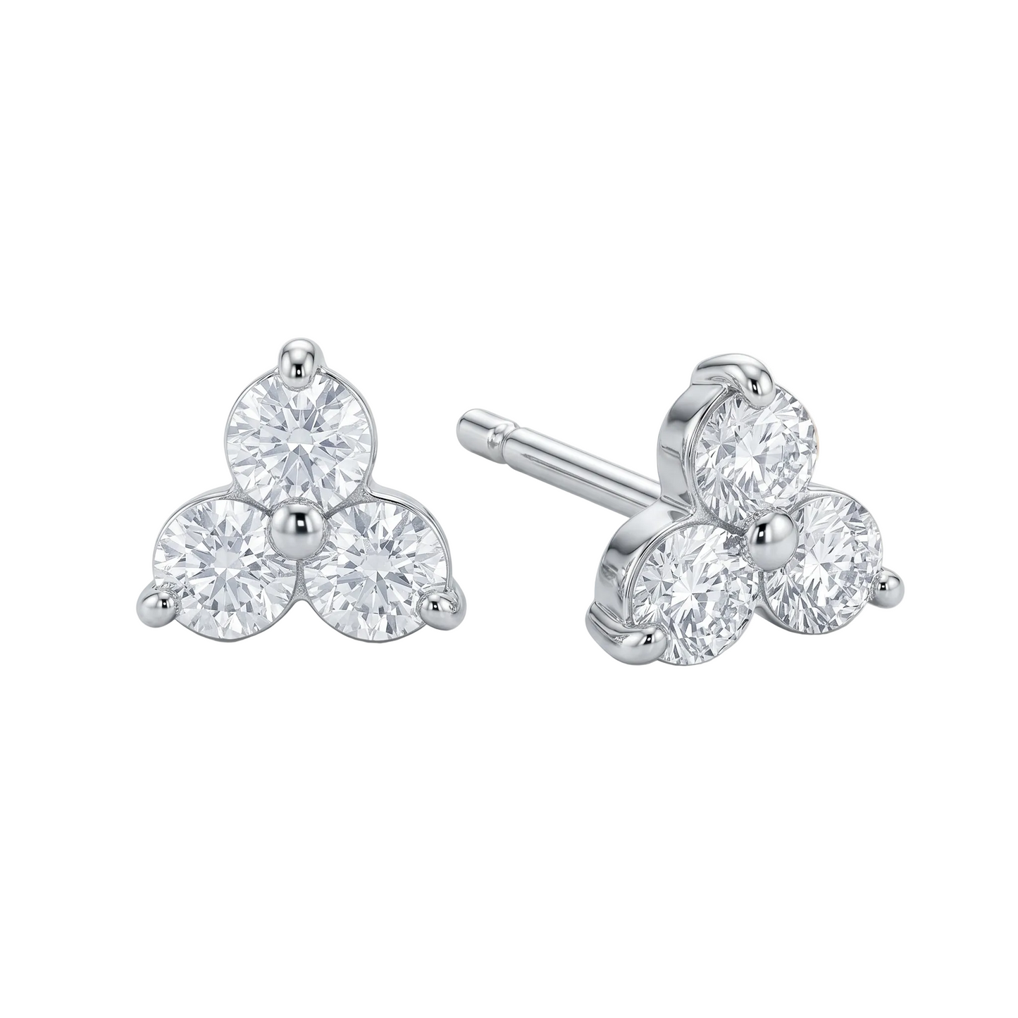 Pair of diamond stud earrings on a wooden surface with a soft focus background