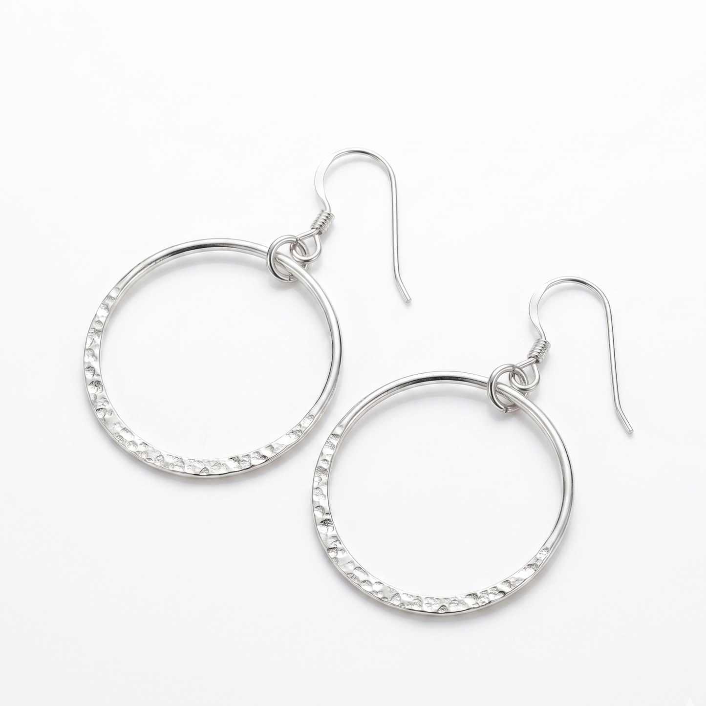 Pair of silver hoop earrings on a white background