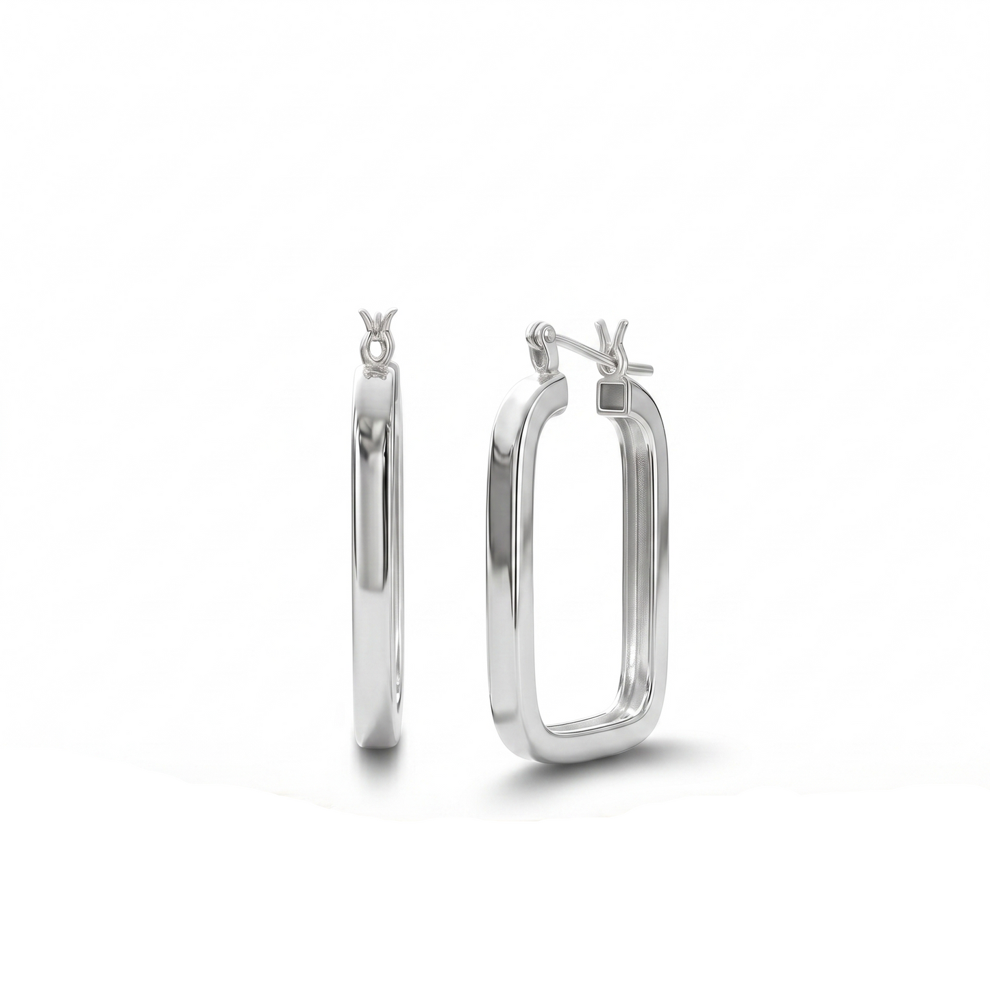 Silver hoop earrings on a wooden surface with a white background