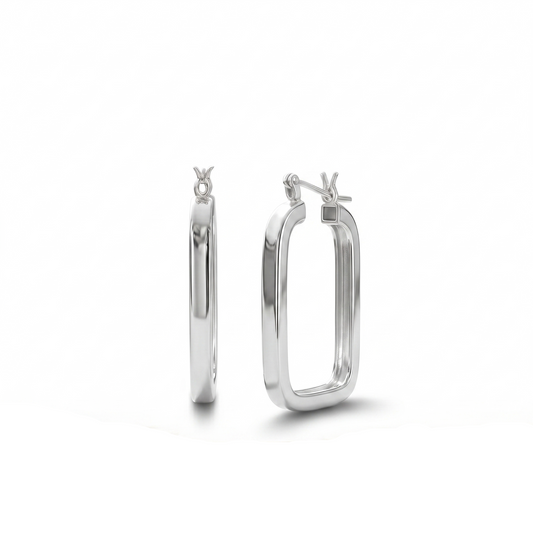 Silver hoop earrings on a wooden surface with a white background