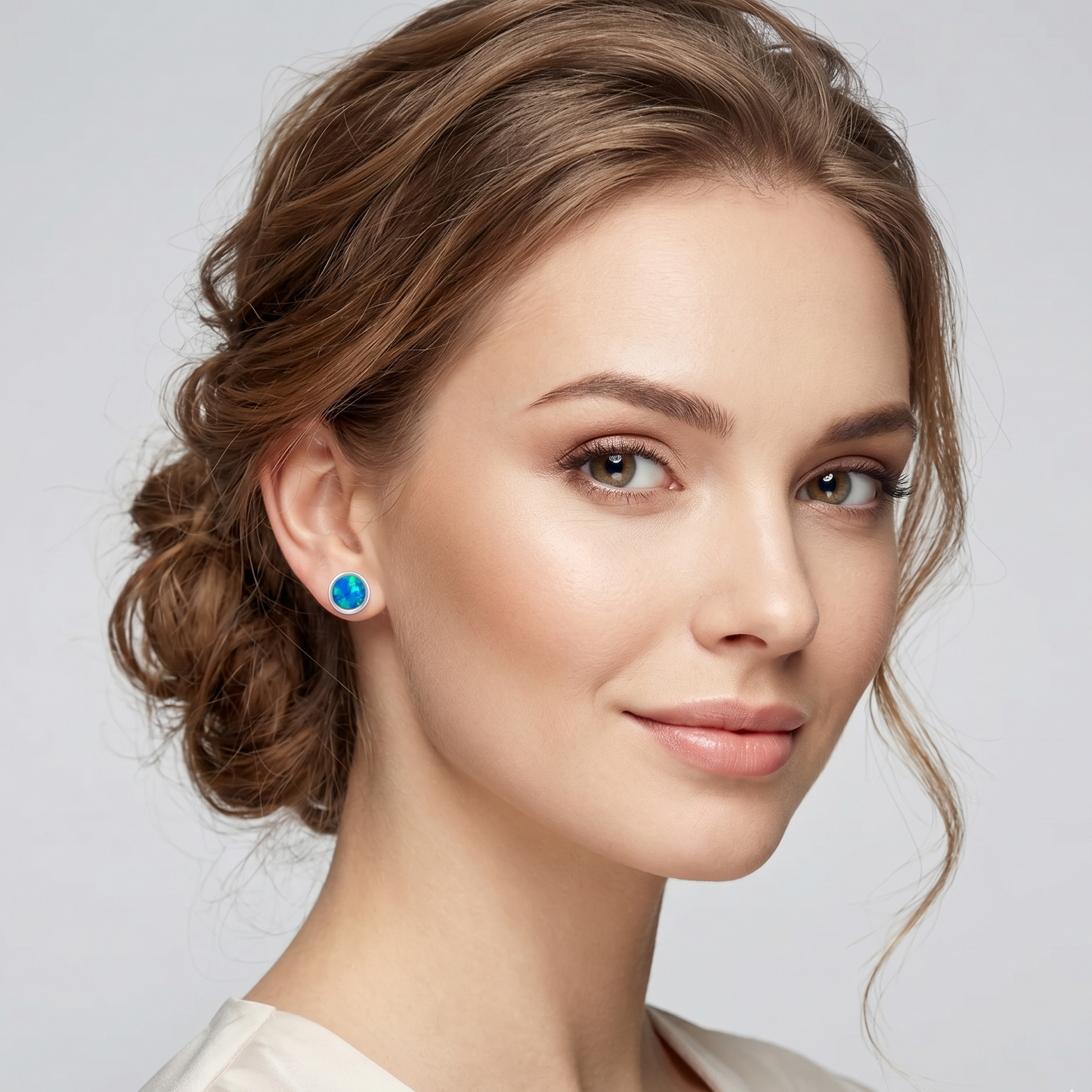 Woman wearing blue earrings with a neutral background