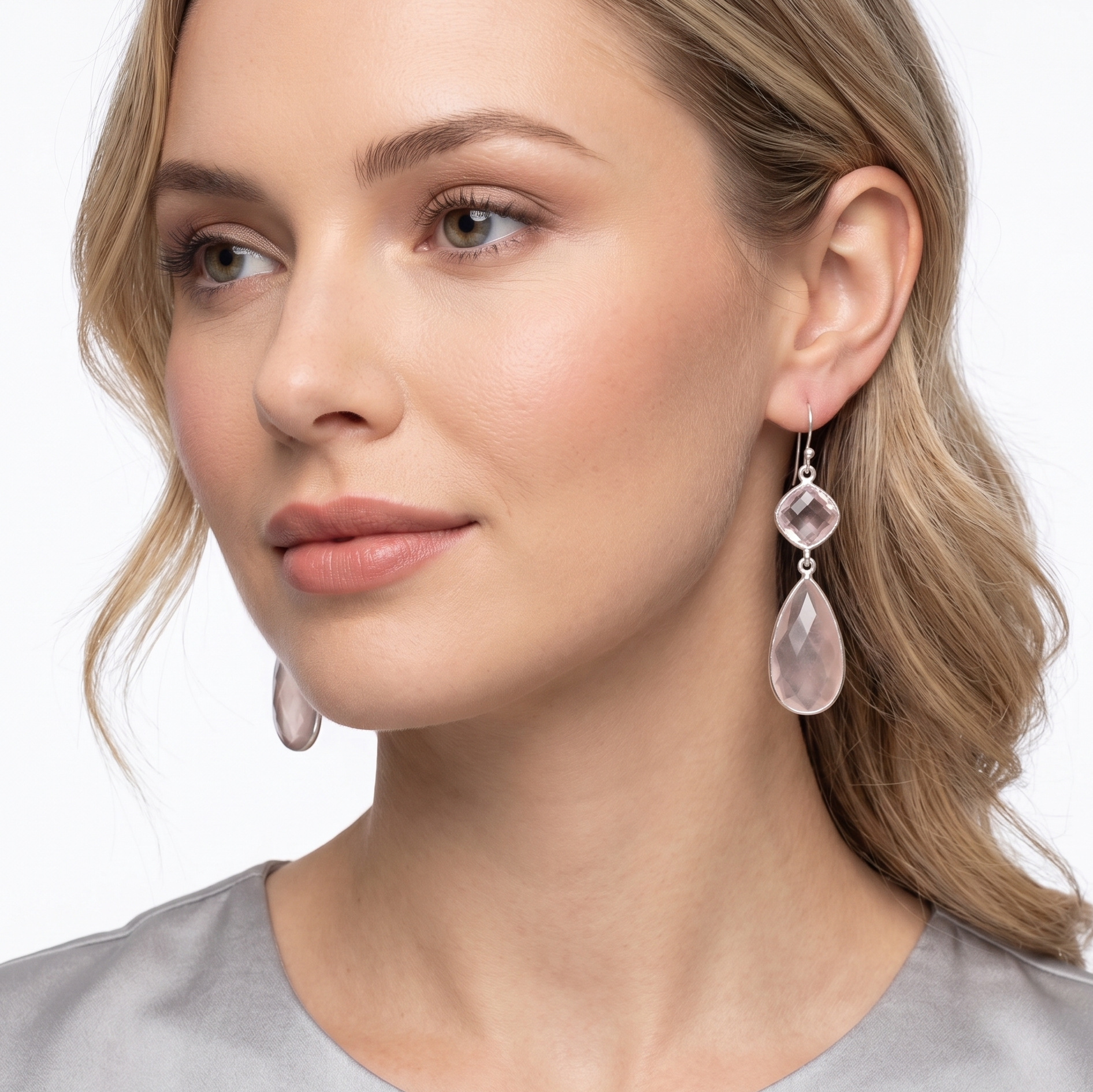 Woman wearing pink teardrop earrings on a white background