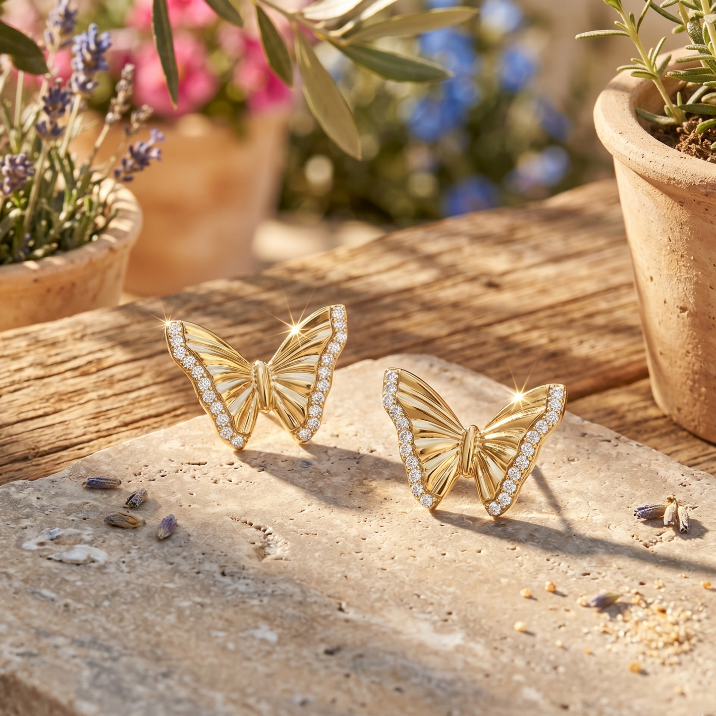 Gold butterfly earrings on a stone surface with plants in the background