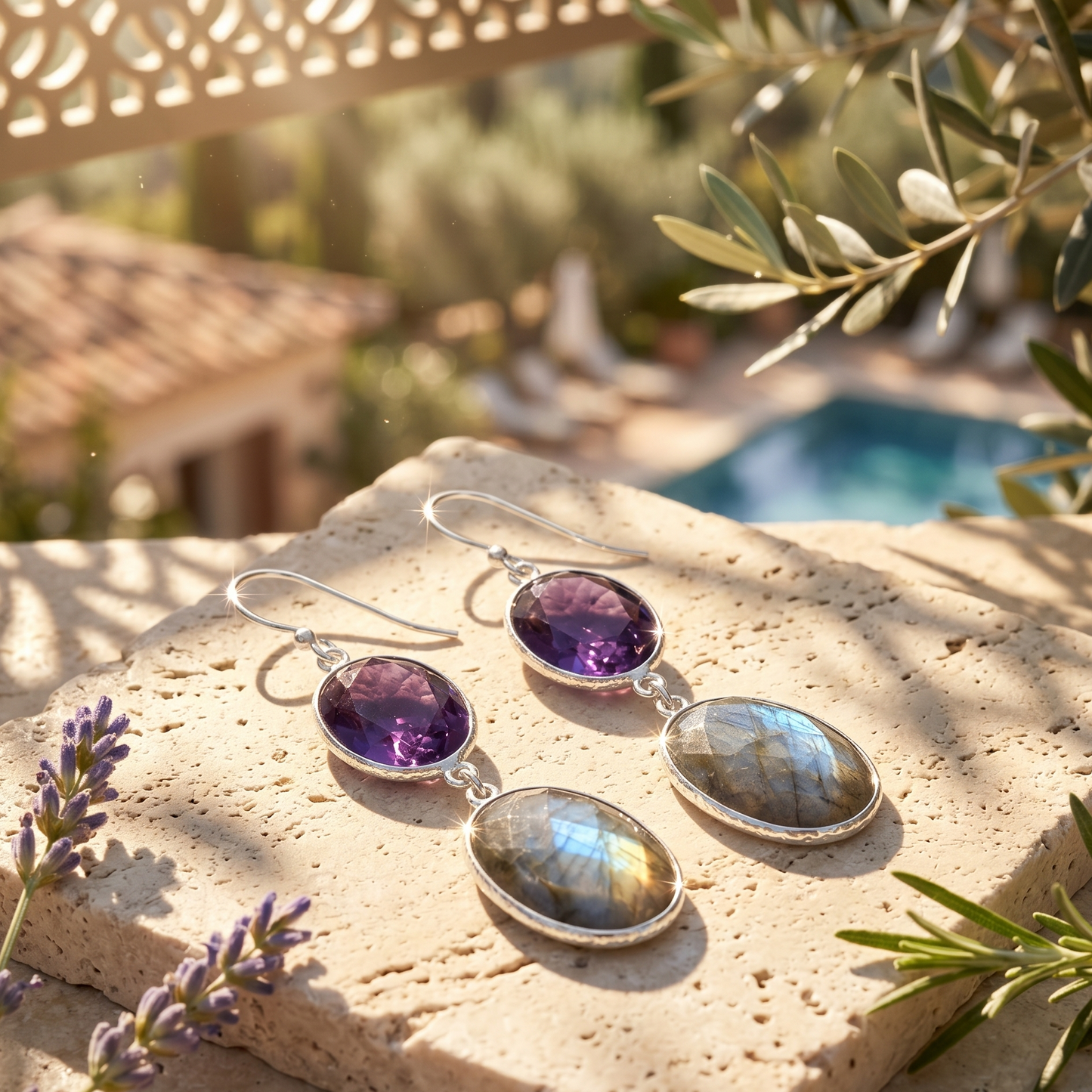 Pair of earrings with purple and labradorite stones on a stone surface with outdoor background