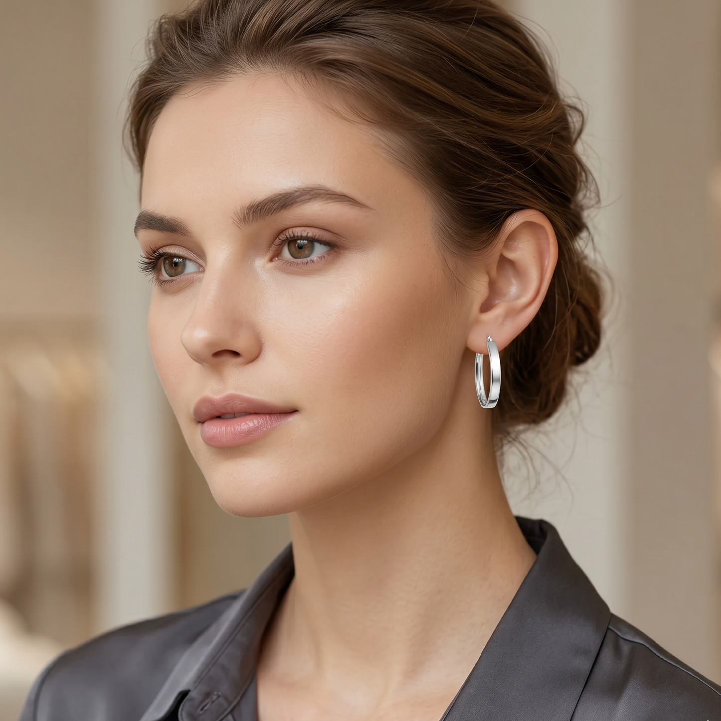 Woman wearing silver hoop earrings with a blurred background