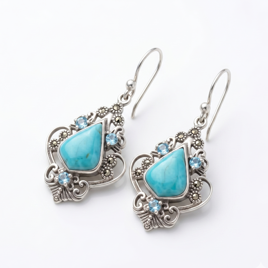 Turquoise teardrop earrings with silver and gemstone accents on a white background