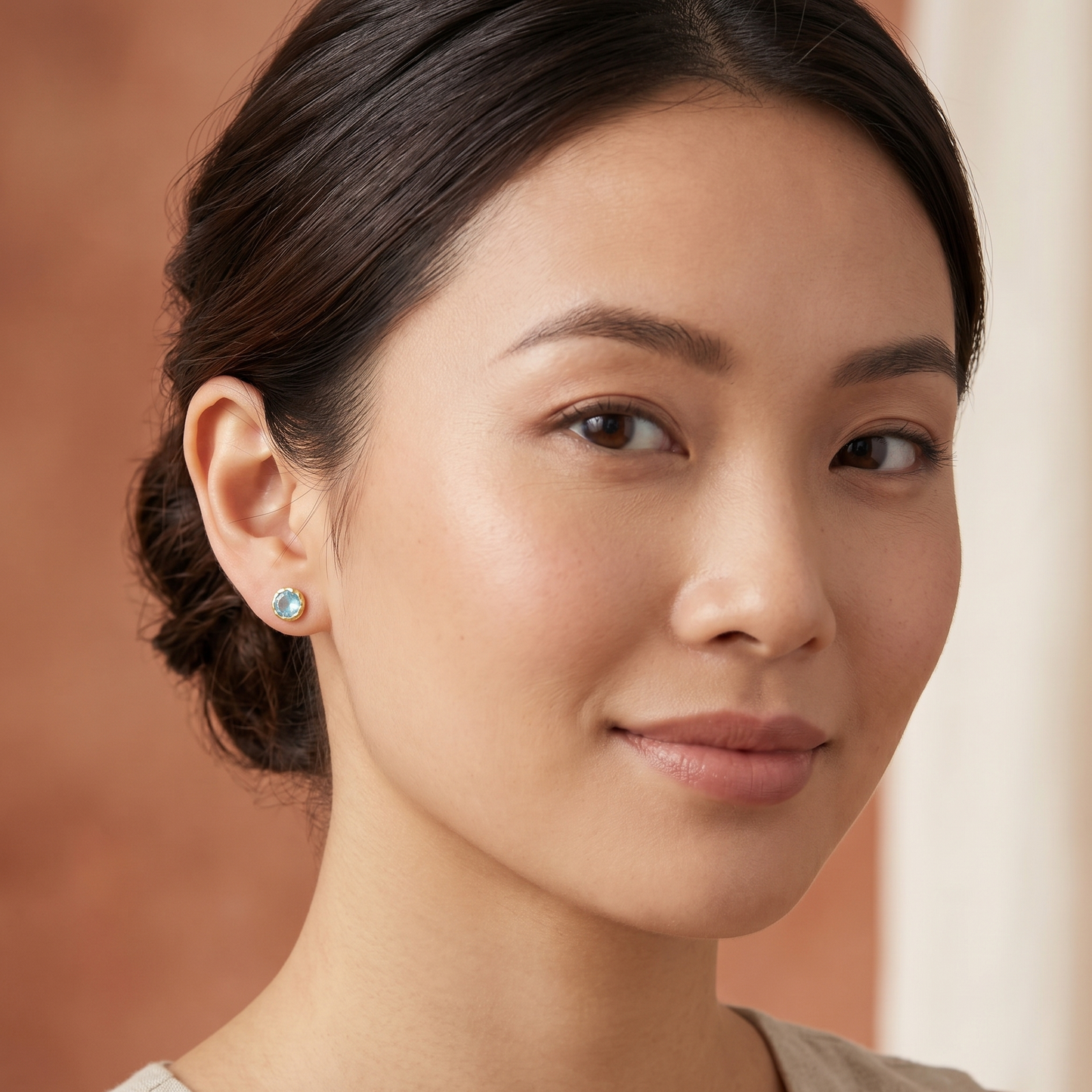 Woman wearing earrings with a neutral background