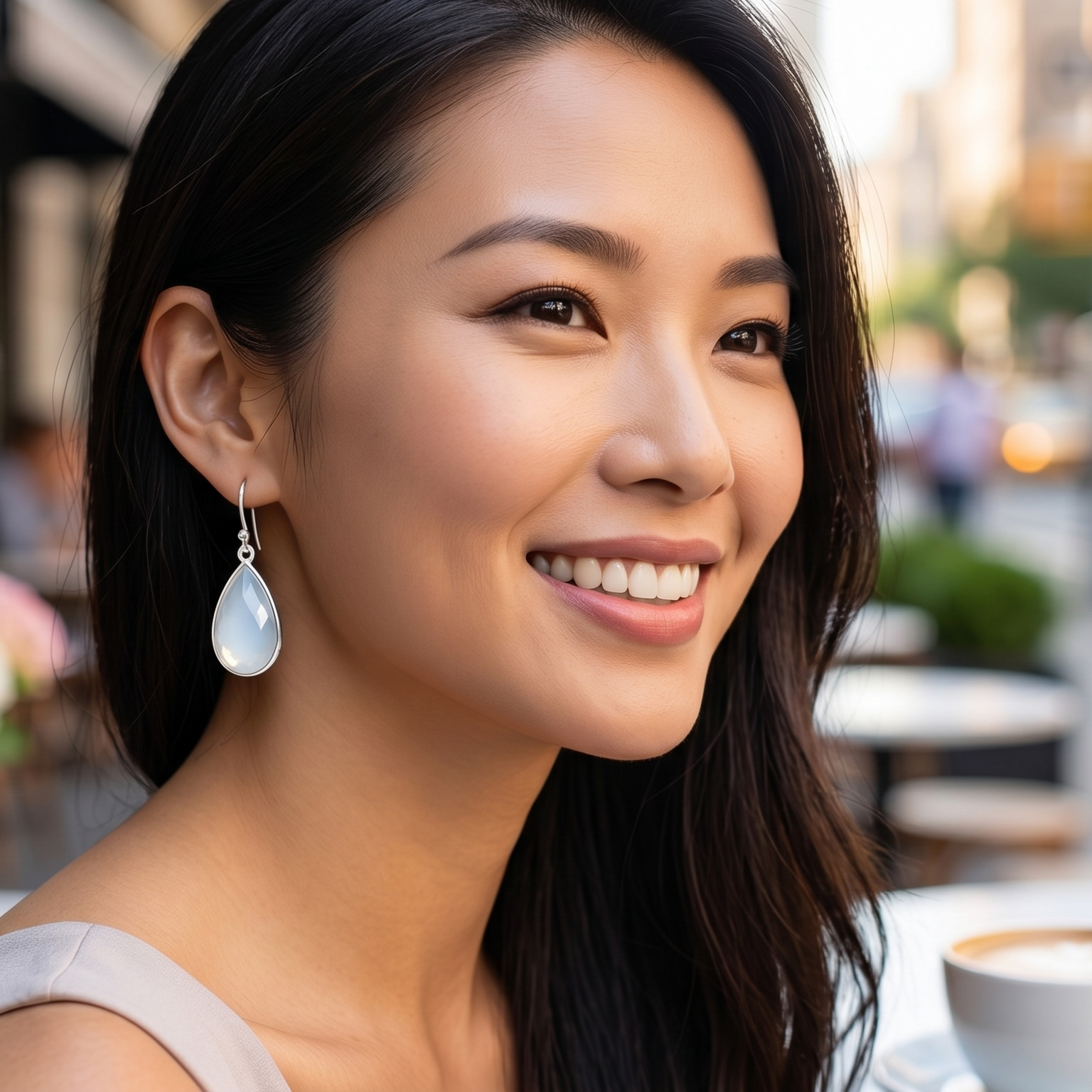 Woman smiling outdoors with a blurred street scene in the background