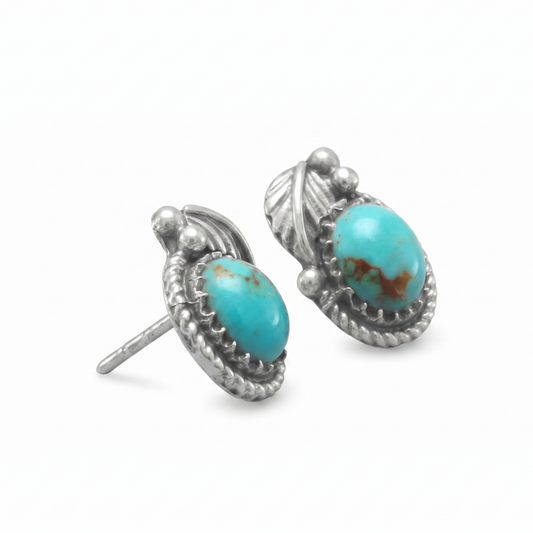 Pair of silver earrings with turquoise stones on a white background