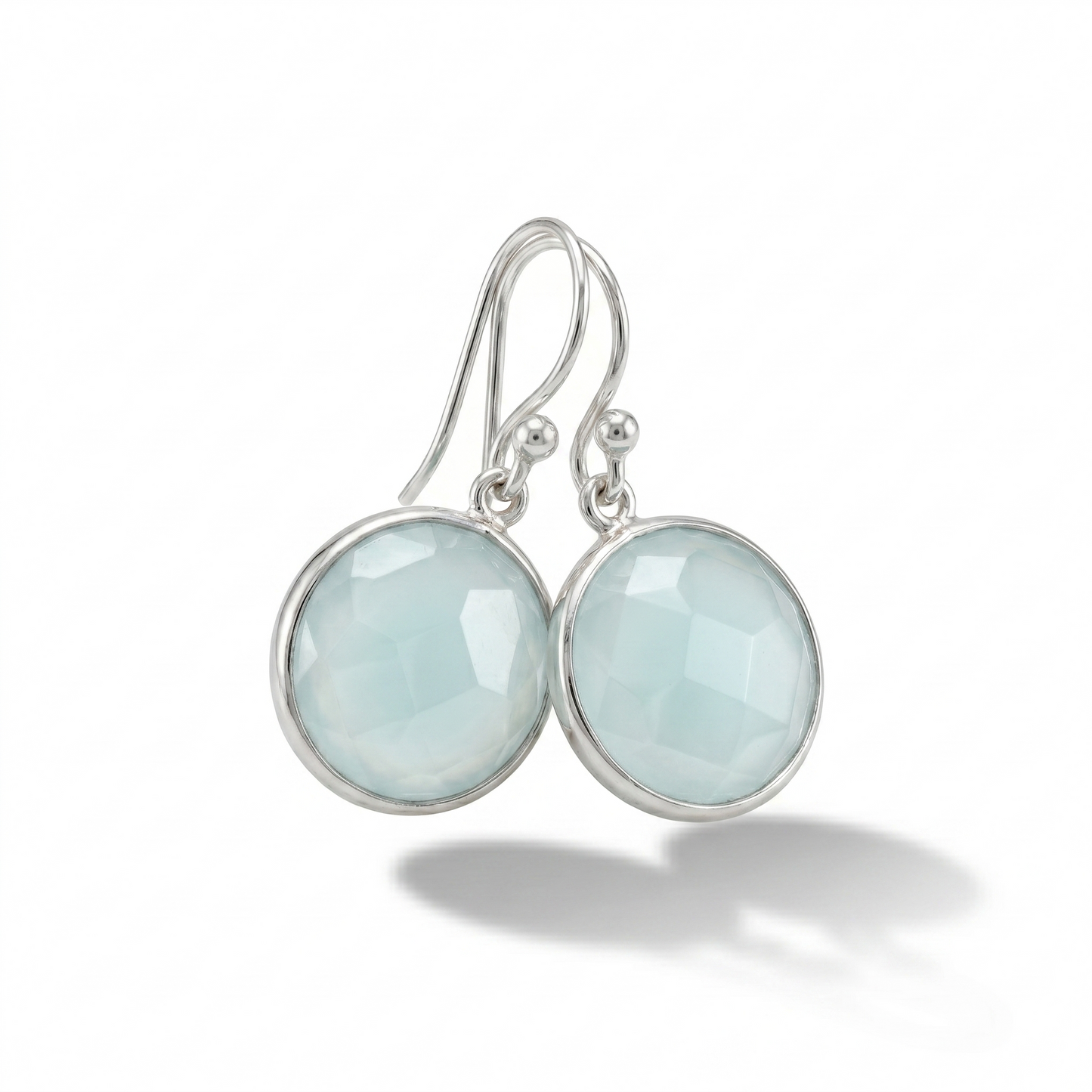 Silver earrings with light blue gemstones on a white background