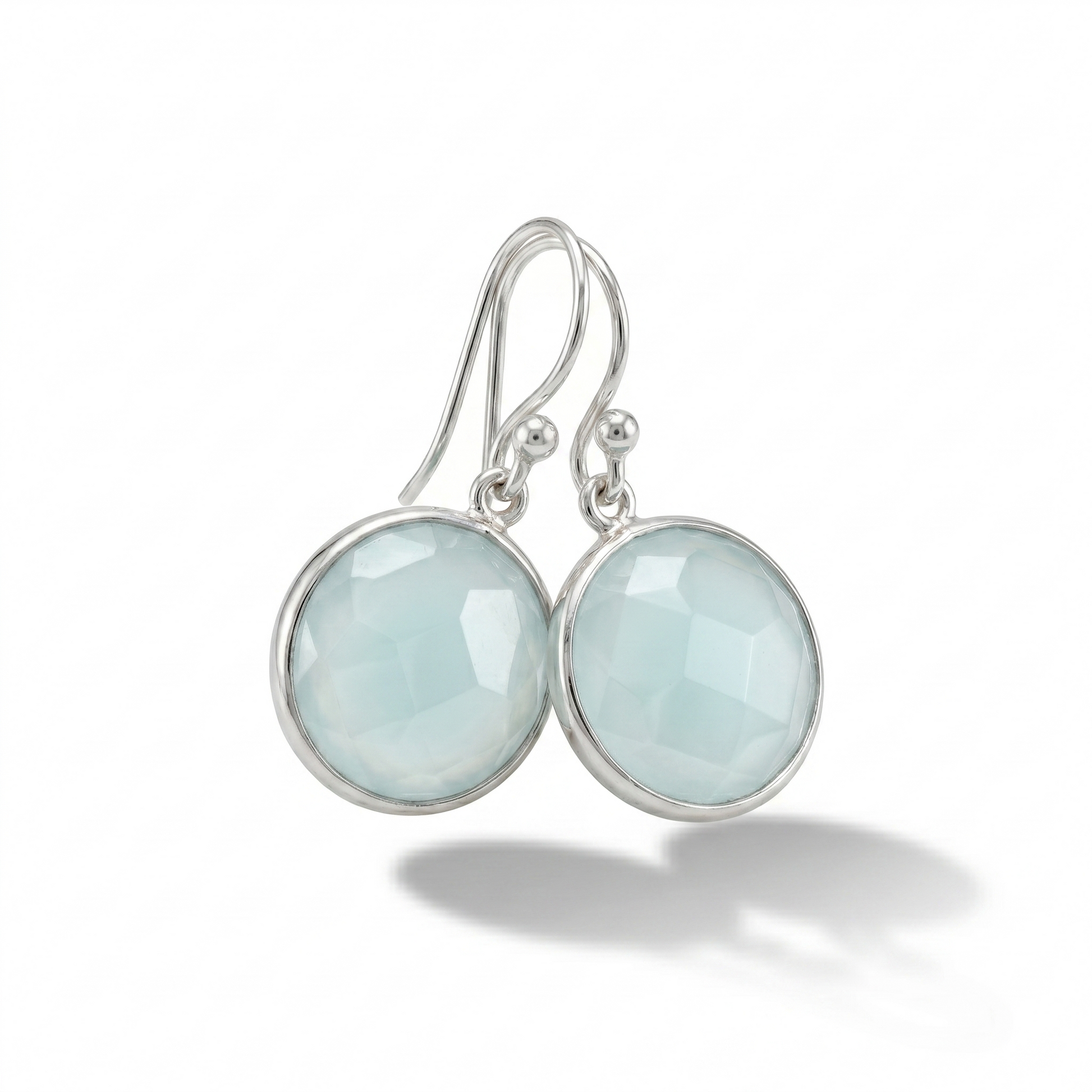 Silver earrings with light blue gemstones on a white background