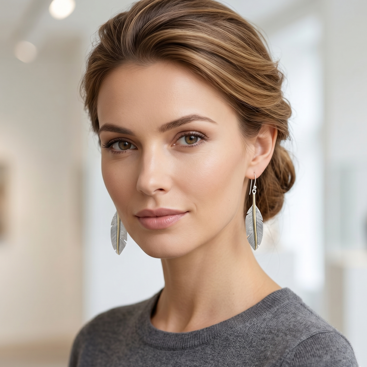 Woman wearing silver earrings with a blurred indoor background