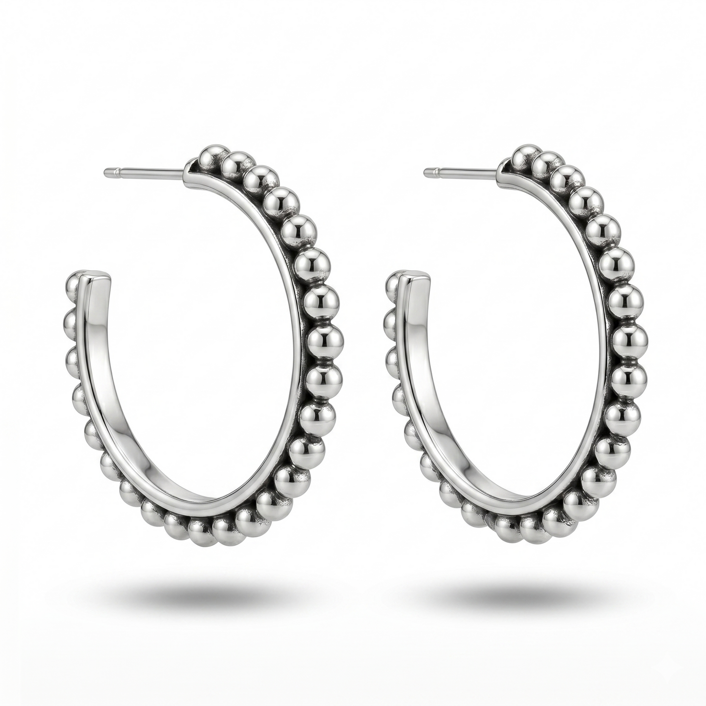Silver hoop earrings with bead detailing on a white background