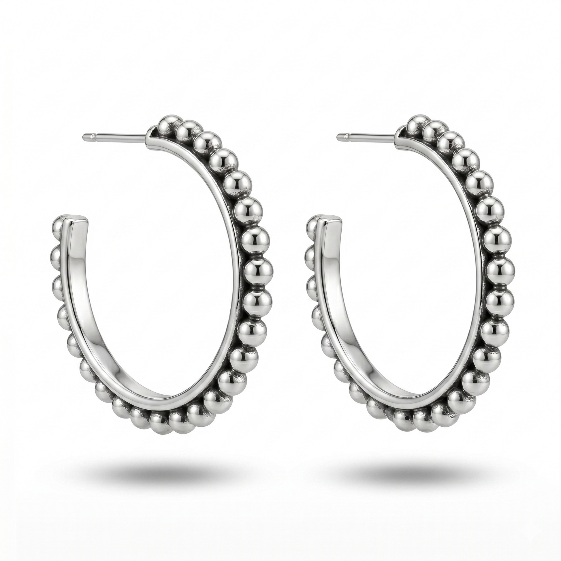 Silver hoop earrings with bead detailing on a white background