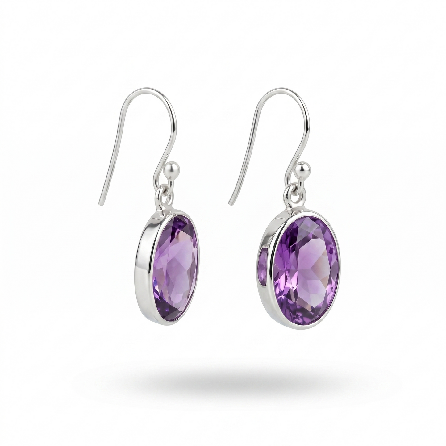 Silver earrings with purple gemstones on a white background