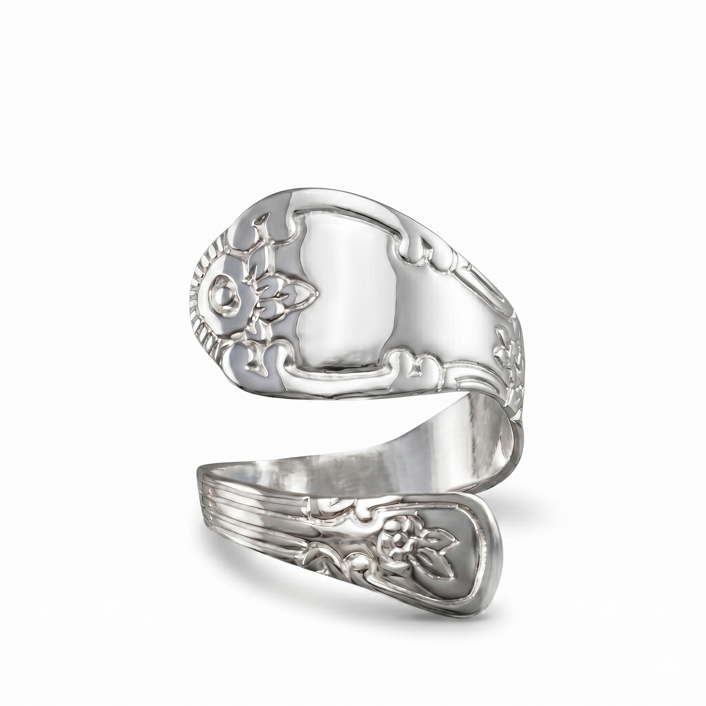 Silver ring with intricate designs on a white background