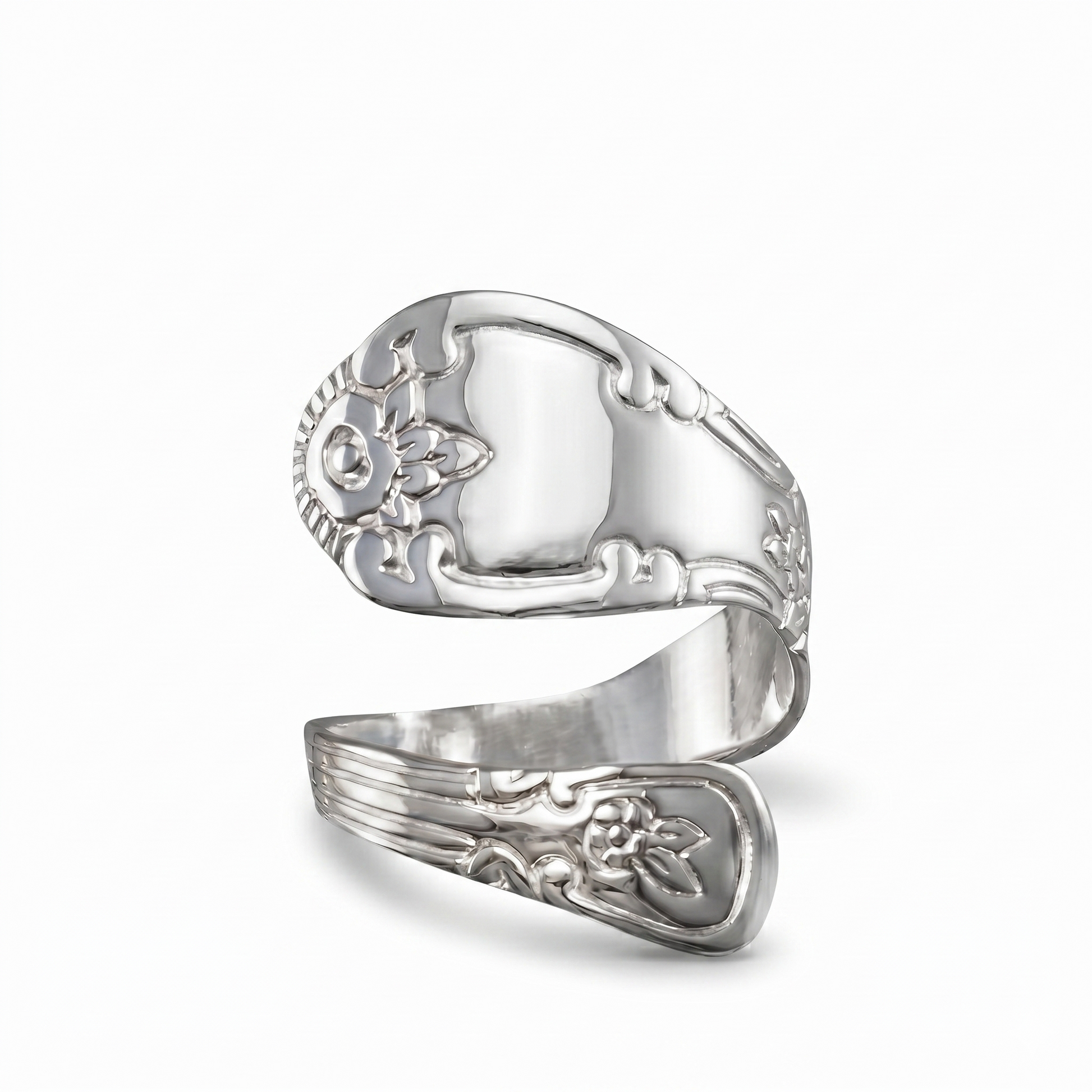 Silver ring with intricate designs on a white background