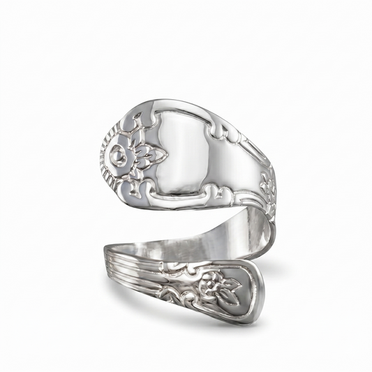 Silver ring with intricate designs on a white background