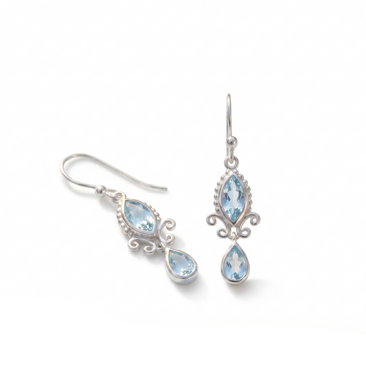 Silver earrings with blue gemstones on a white background