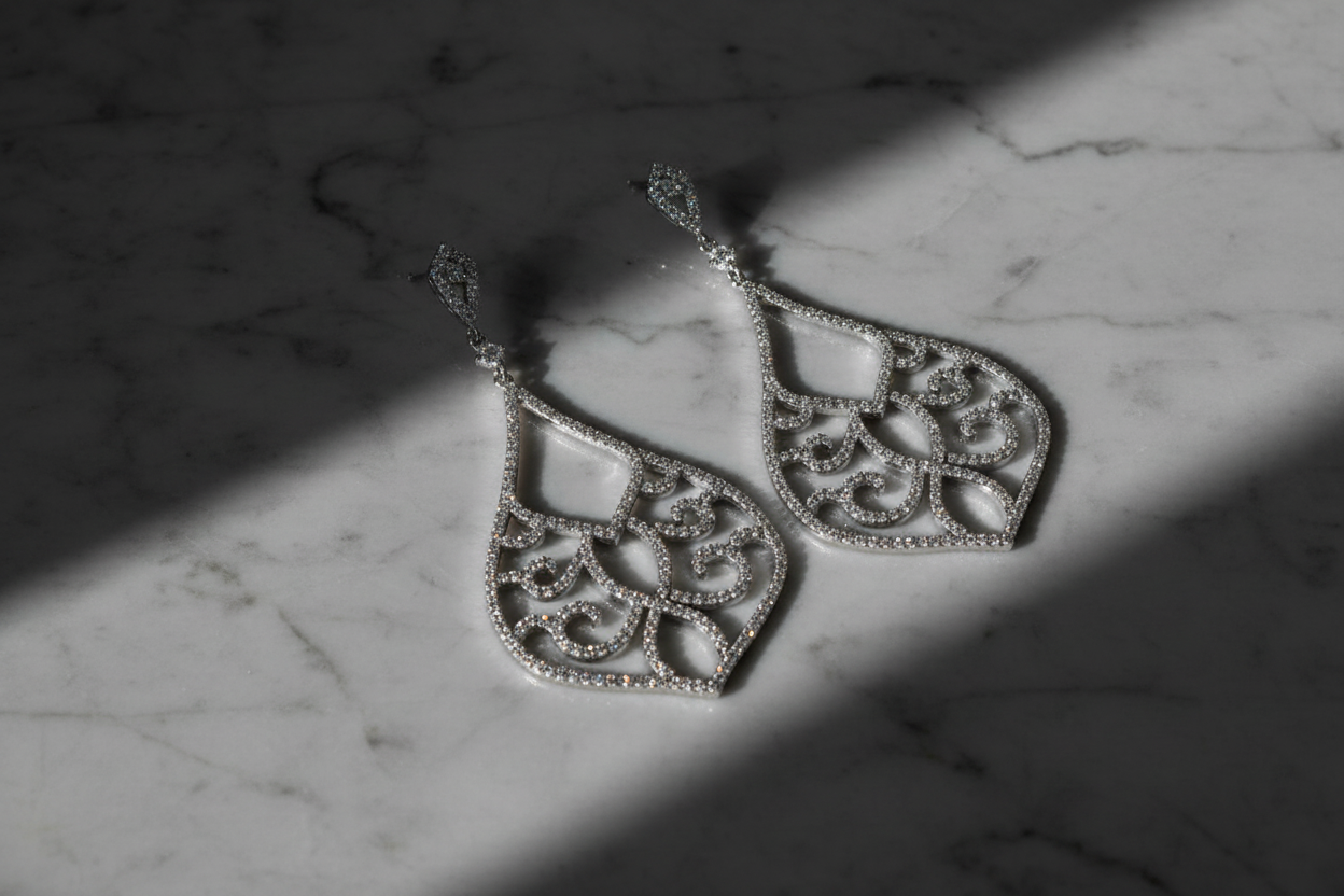 Chandelier earrings on grey marble with dramatic lighting