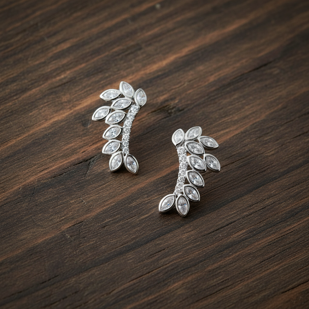 CZ leaf earrings on dark walnut wood