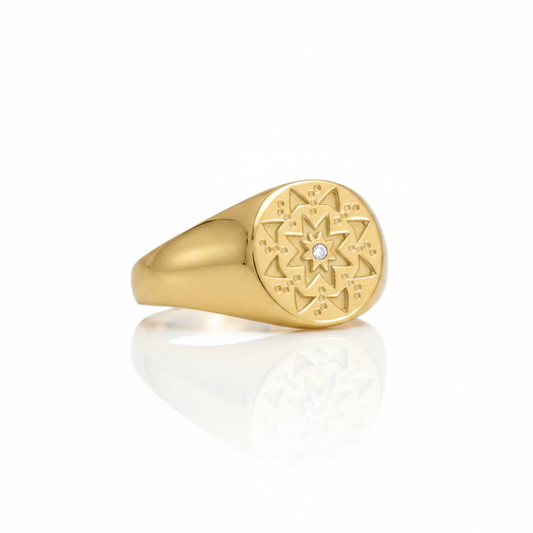 Gold Signet Ring Mandala Star Engraving Center CZ Stone Wide Tapered Shoulders Pure White Background Tilted Reflection 1x1
