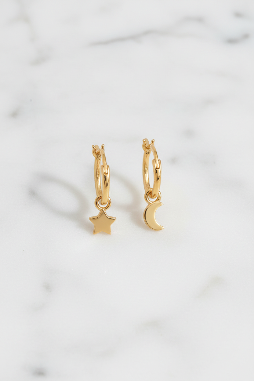 Golden celestial mismatch hoops on white marble