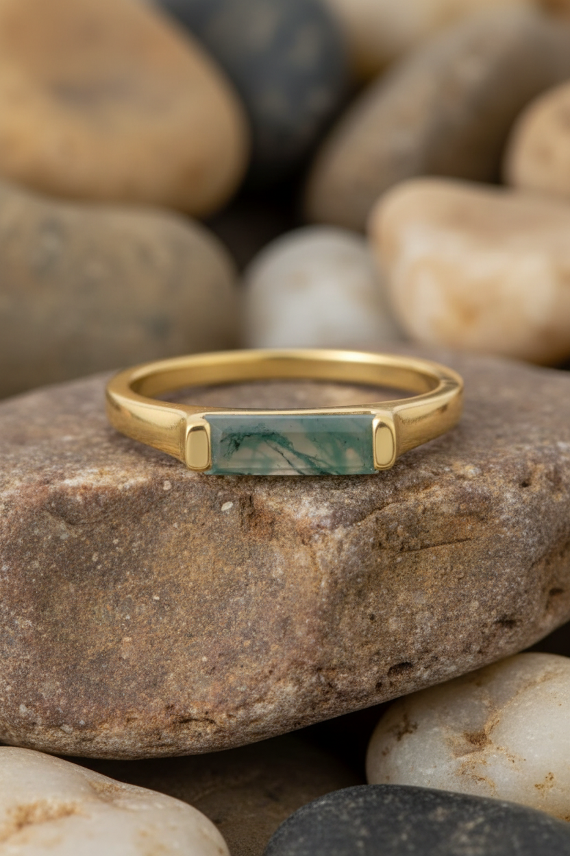Moss Agate Gold Bar Ring on Rock Background