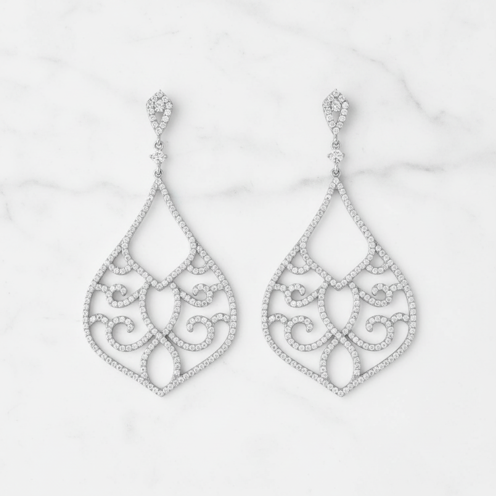 Ornate chandelier earrings on white marble