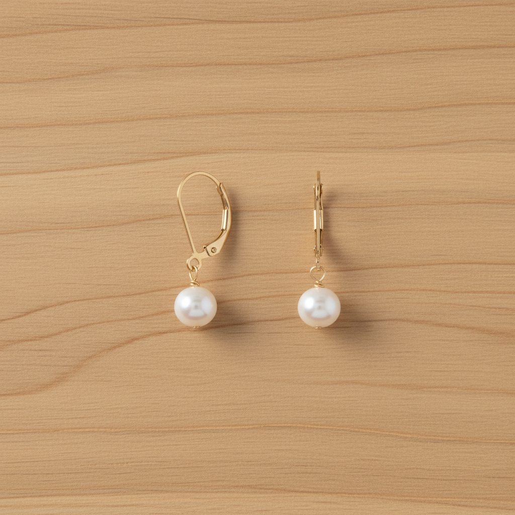 Pearl essence earrings on light oak wood