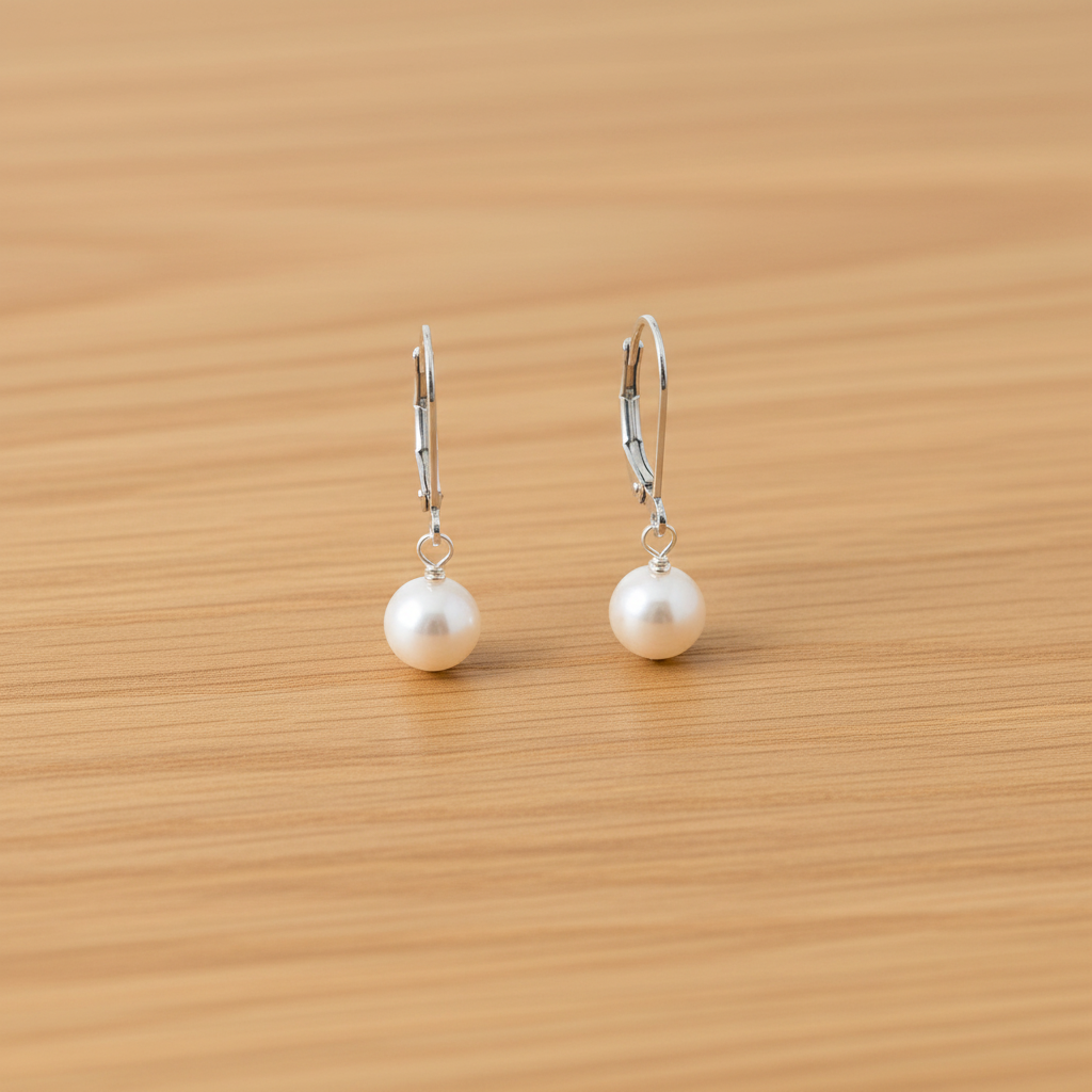 Pure pearl earrings on light oak wood